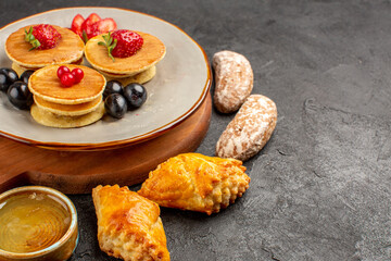 front view yummy pancakes with olives and cakes on a dark background fruit sweet cake