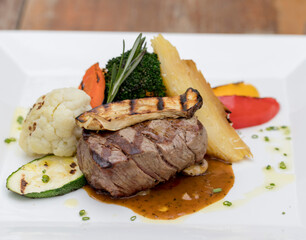 Chargrilled beef tenderloin with mixed vegetables, potato gratin and mushroom sauce