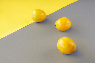 Lemons on yellow and gray background. Trendy colors 2021. Minimal composition, top view, copy space