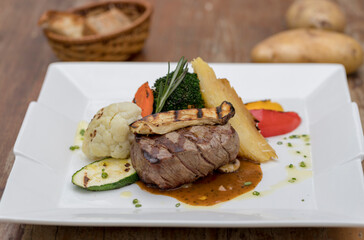 Chargrilled beef tenderloin with mixed vegetables, potato gratin and mushroom sauce