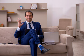 Young male employee working from home in pandemic concept