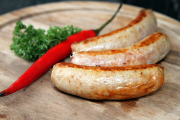 Grilled chili sausages on a wooden plate