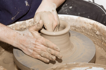 Hands working on a clay pot