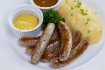 Six grilled Bavarian Nuremberg sausages served with potato mash, dark beer jus and mustard