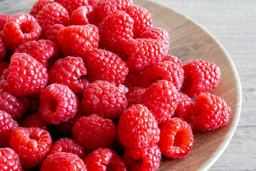 Framboises sur une assiette en bois