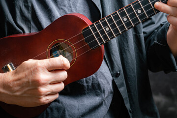 Fototapeta premium macro close-up of ukulele in brown details with dark background and backlight