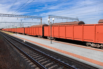 Obraz premium gondola car transports goods by rail to export raw materials, transport industry logistics products on a sunny day with a blue sky nobody.