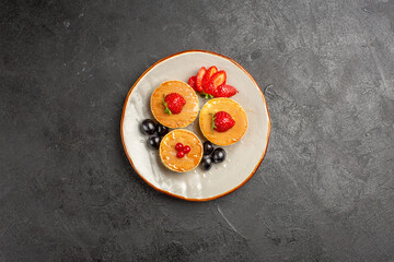 top view yummy pancakes little formed with fruits on a dark background fruit cake pie