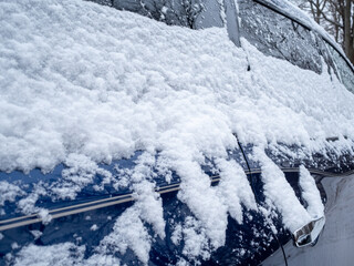close view of blue car covered with snow in winter