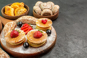 front view yummy pancakes with fruits and sweet cakes on dark desk sweet cake dessert