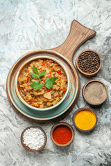 top view roasted eggplant salad in bowl different spices in bowls on grey background