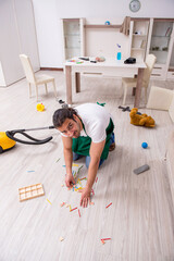 Young male contractor cleaning the flat after kids' party