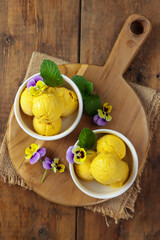 es cream mangga. Mango ice cream sorbet with mint leaves and edible flower pansy viola
