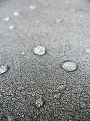 water droplets on a textured grey stone