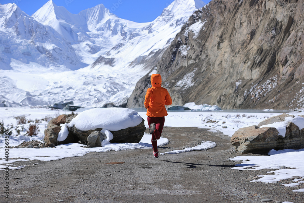 Wall mural woman trail runner cross country running in winter nature