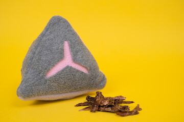 Close up soft pad with many holes for treats, special device for dog nose work. Training sniffing equipment, yellow background, some pieces of dry meats near, copy space