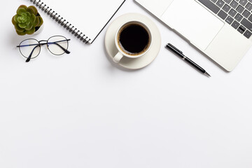 Top view white office desk with notebook, Laptop computer and Coffee cup with ,office supplies on white background