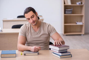 Young male student preparing for exams at library