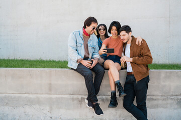 Group of friends taking a selfie with phone.