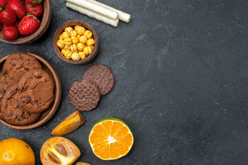 top view fresh red strawberries with sweet biscuits on dark background fresh sugar cookies