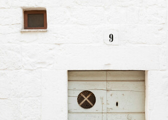 Vecchia porta d'ingresso con finestrino sul muro