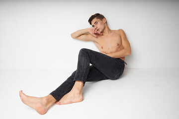 Obraz premium Man sitting on floor naked torso isolated background fashion luxury