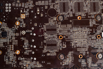 Fragment and components of a motherboard (PCB) of computer technology with many elements. Macro photography of processors and transistors. IT industry background