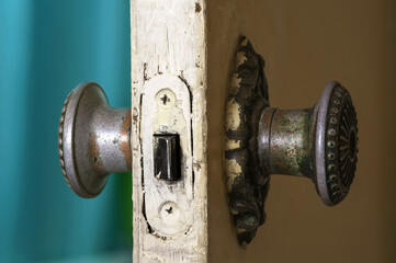 Vintage copper door handles on the shabby white door, selective focus