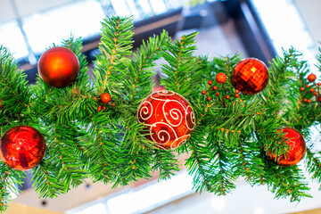 Decorated red Christmas baubles with a branch of a Christmas tree hanging in the market