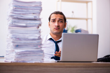 Fototapeta premium Young male employee unhappy with excessive work