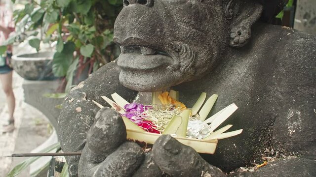 Sacred Monkey Statue Offered With Flowers And Incense Situated Along The Street Of Ubud, Central Bali, Indonesia - Closeup Shot