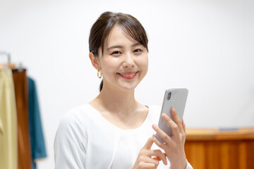 アパレルショップ　スマホを使う女性