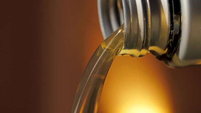Motor Oil Flows from Neck of Bottle. Liquid Stream Close-up