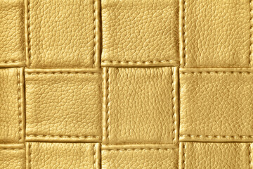 Texture of golden and yellow leather background with square pattern and stitch.