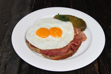 Famous German meal called Strammer Max. Fried eggs and ham on sourdough bread, served with gherkins