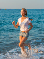 Sportswoman is jogging on the beach near the ocean.