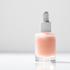 Face Serum in crystal  bottle on white podium. Home skin care routine and eco packaging concept.