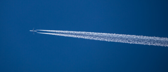 Flieger zieht Kondensstreifen