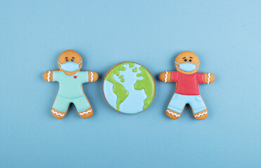 two gingerbread man medics in a mask with the gingerbread planet earth on a blue background