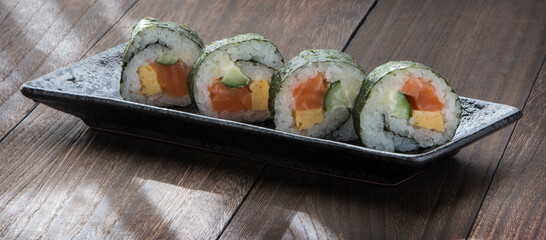 Japanese food .  Sushi Rolls in closeup on a black dish. Makizushi. Rectangular dish