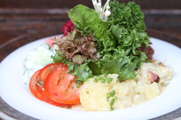 Mixed salad platter with greens ,tomato, cucumber and potato salad