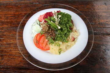 Mixed salad platter with greens ,tomato, cucumber and potato salad