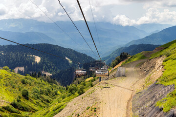 Fototapeta na wymiar Chairlift in a mountain region in summer. Life of ski resort in summertime