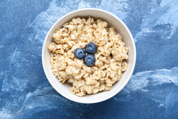 Bowl with tasty sweet oatmeal on table