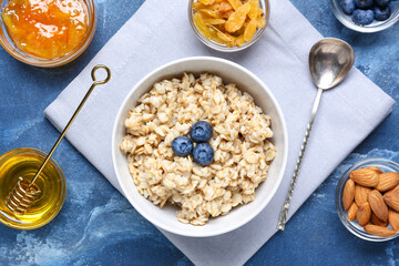 Bowl with tasty sweet oatmeal on table