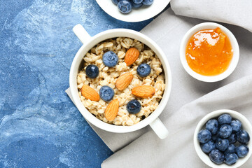 Bowl with tasty sweet oatmeal on table