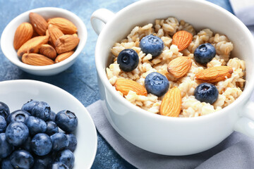 Bowl with tasty sweet oatmeal on table
