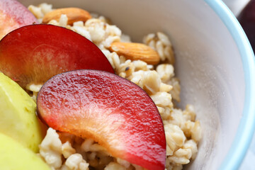 Bowl with tasty sweet oatmeal, closeup