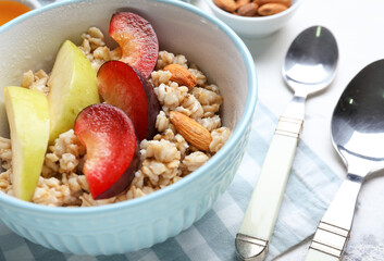Bowl with tasty sweet oatmeal, closeup