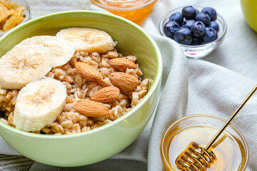 Bowl with tasty sweet oatmeal, closeup